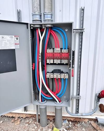 Exterior electrical disconnect enclosure with colour-coded three-phase conductors terminated to fused switches
