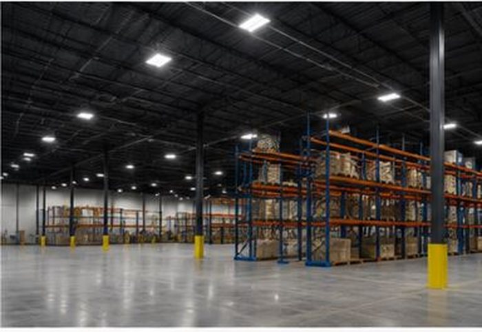 Large warehouse interior with LED high-bay lighting illuminating storage racking